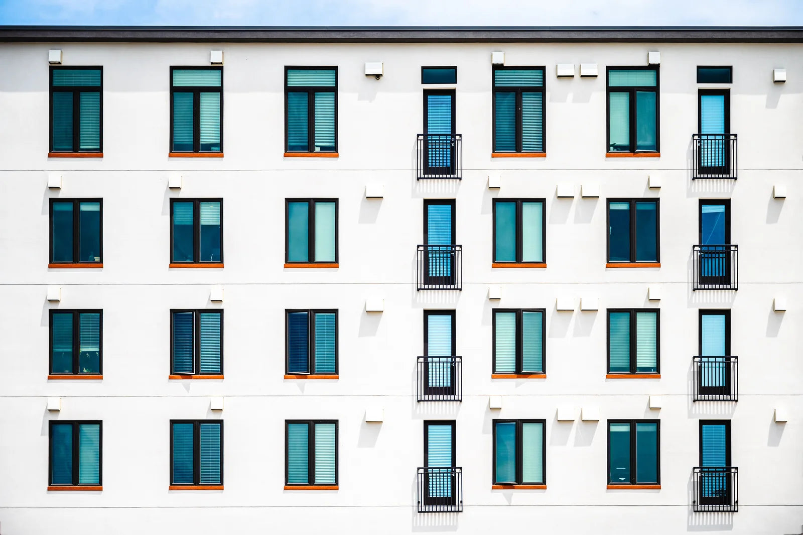 Clean architectural lines and repeated windows on a modern residential building.